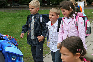 Kinder mit Kreuz-Ketten auf dem Weg zur Schule